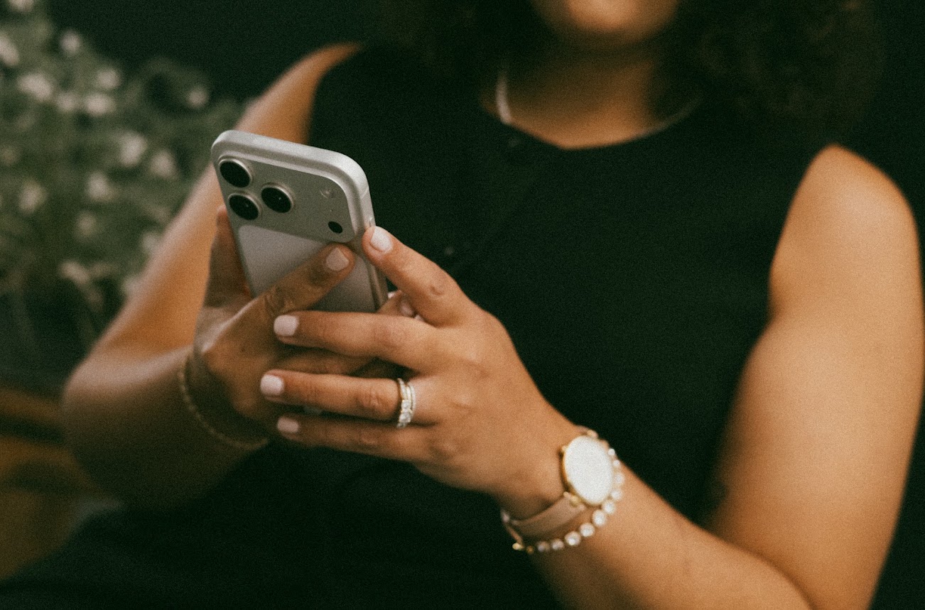 Checking a phone, close-up with watch and pearl bracelet